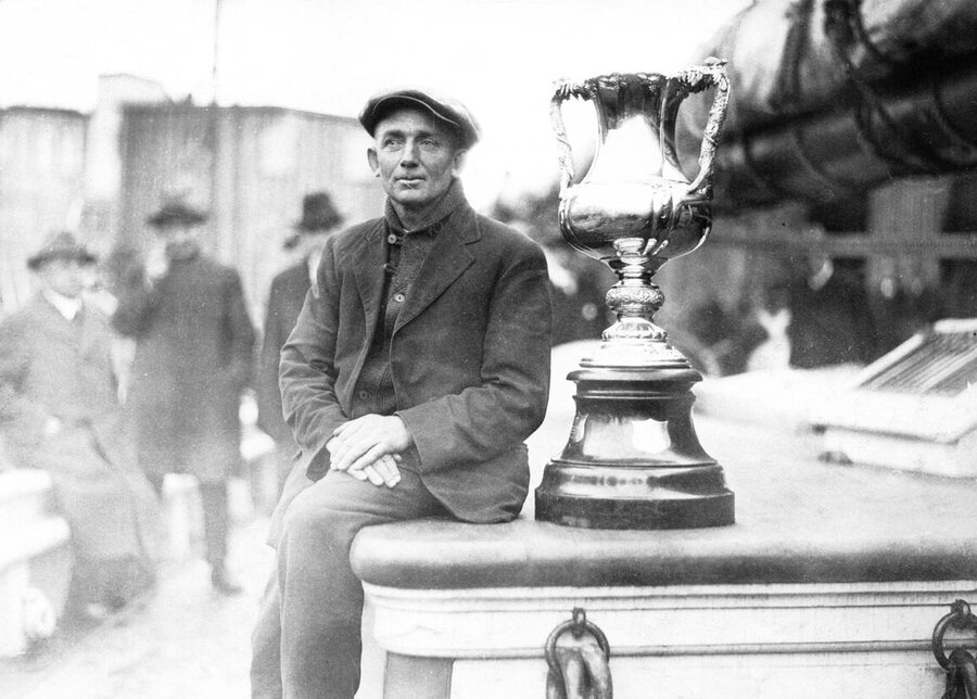 Captain Angus Walters aboard Bluenose beside the International Fishermen's Trophy