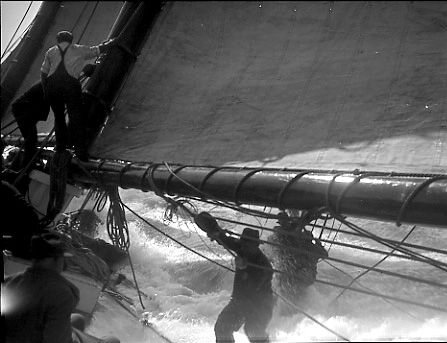 A racing schooner shipping green water in heavy seas